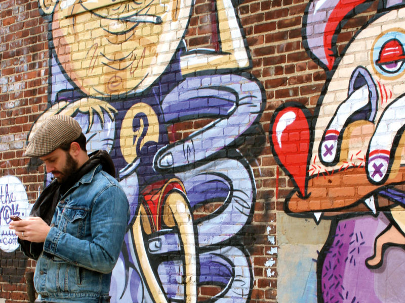 One of Brooklyn's many resident hipsters takes a break alongside some local street art.