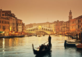 Sunset over the Grand Canal and the famous Rialto Bridge.