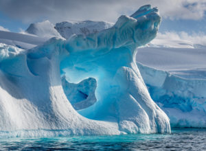 A dramatically shaped and weather eroded iceberg floating in Wilhemina Bay Antarctica