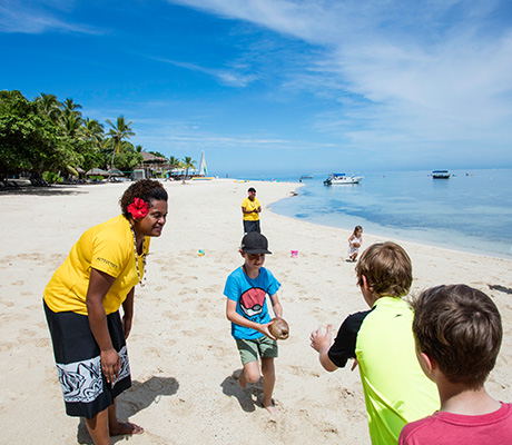 Outrigger Castaway employee and kids playing on beach, Fiji