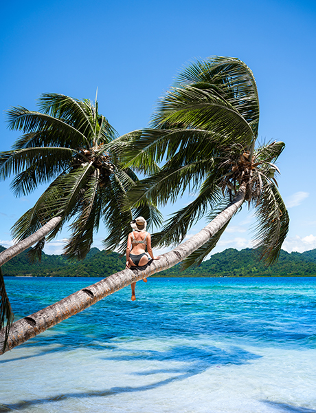 Lady sitting on palm tree, Fiji