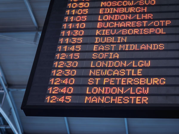 Flight schedule appears on board at international airport