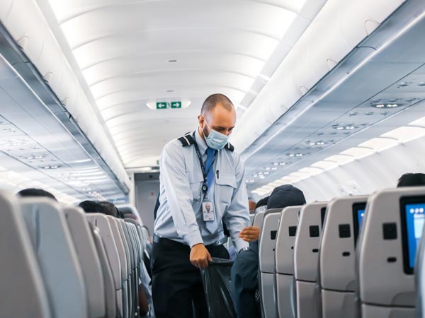 Cabin crew collects rubbish from passengers