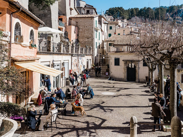 People enjoying coffee in the sun in a piazza in Italy