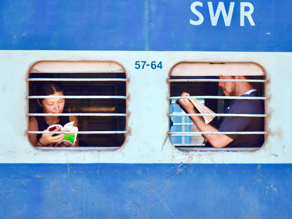 Strangers sit opposite each on a train in India