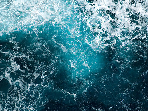 Deep turquoise water of the Mediterranean Sea shows it's power when waves crash on the cliffs of Capo Caccia, Sardinia.