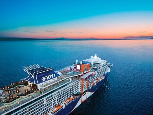 The Celebrity Beyond cruise ship in the ocean as the sun sets on the horizon. (Image: Celebrity Cruises)