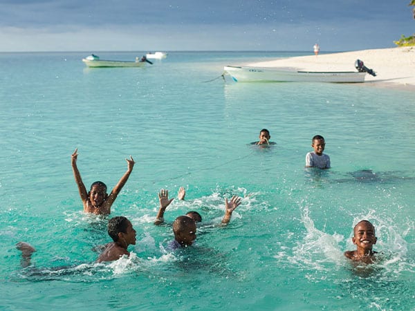 beach village kids swimming, Fiji Islands, Oceania