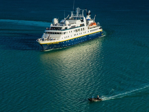 Lindblad Expeditions ship sailing in the sea with smaller boat in front. (Image: Lindblad Expeditions)