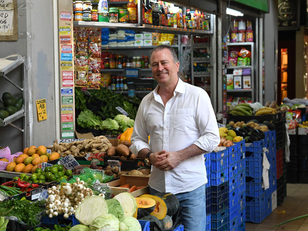 A man standing by vegetable produce in Rome, Italy