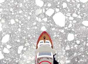 Aerial view of the MS Roald Amundsen breaking through ice