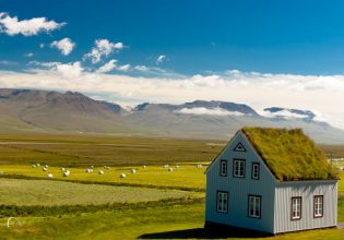 Old farm with mossy roof and typical Icelandic landscape
