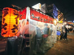 customers dining behind the curtains inside a Yatai food stall along Fukuoka