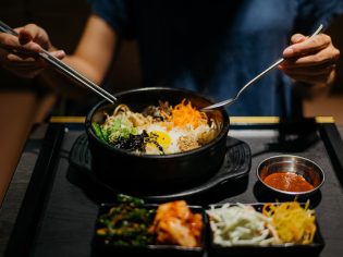 Woman eating bibimbap in Korean restaurant