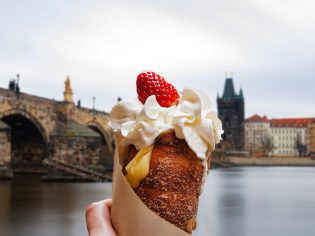 a hand holding Trdelník in Prague