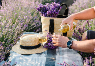 pouring some Provence wine into a glass on the lavender fields