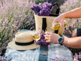 pouring some Provence wine into a glass on the lavender fields