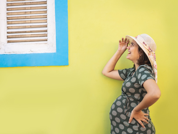 a pregnant woman posing on a yellow background