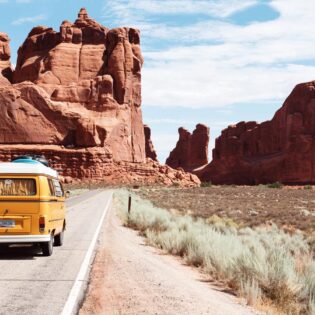 Yellow Volkswagen bus driving through Utah