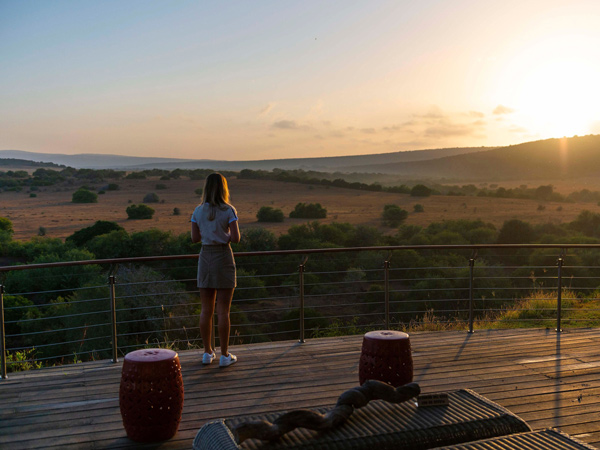 a woman relaxing on the balcony at sunrise, Shamwari Private Game Reserve