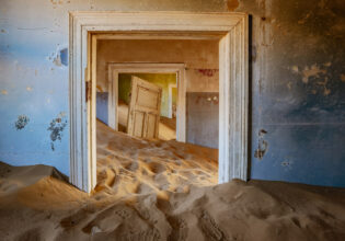 sand dunes covering the floor of an old house in Kolmanskop, Namibia