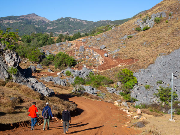 Intrepid travellers walking from Rabilau’s Animist/Catholic shrine to the village itself