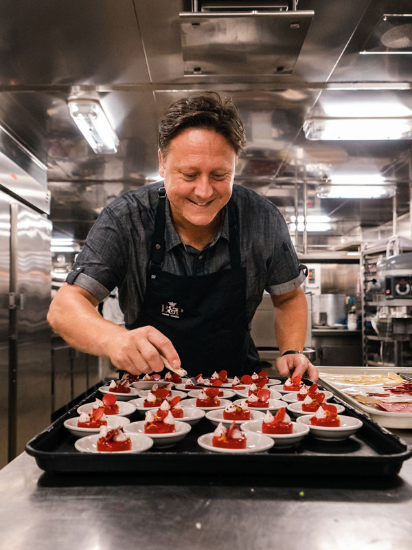pastry chef Darren Purchese posing for a photo while preparing desserts