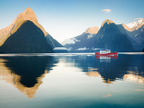 a boat at dawn in Milford Sound