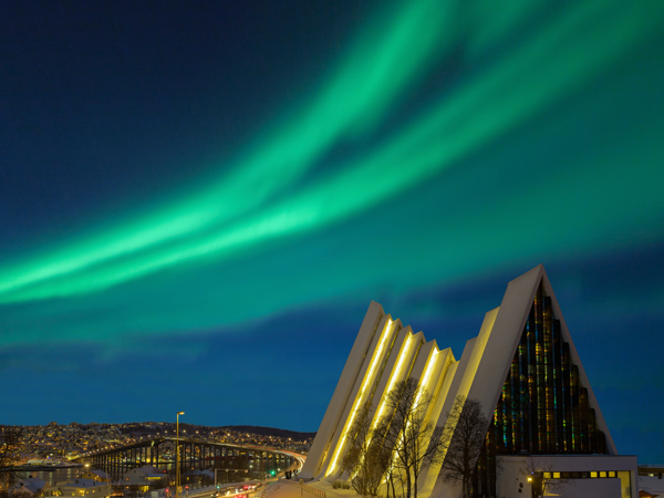 the Tromsø Cathedral at night with aurora borealis in the background