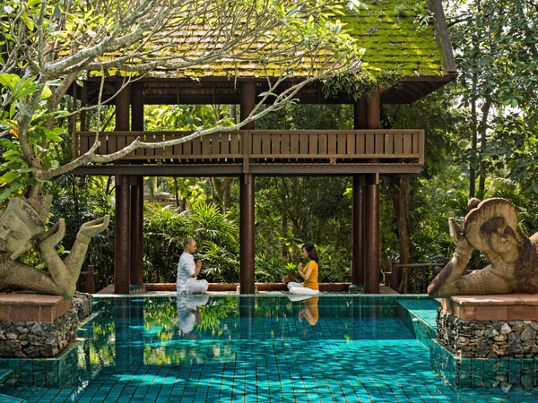 two people meditating by the pool at Four Seasons Resort Chiang Mai