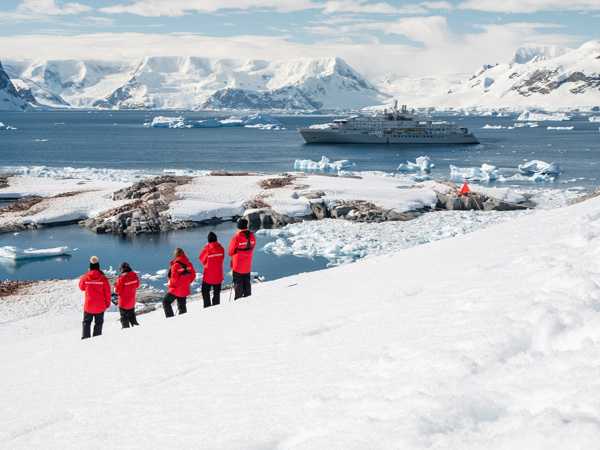 a group of travellers standing on a snow-covered landscape in Neko Harbour