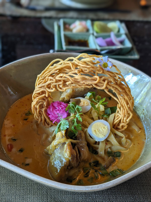 a bowl of creamy, caramelised khao soi