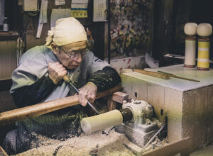 An artisan making a kokeshi doll