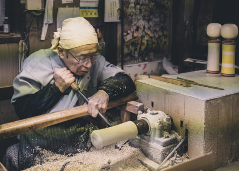 An artisan making a kokeshi doll