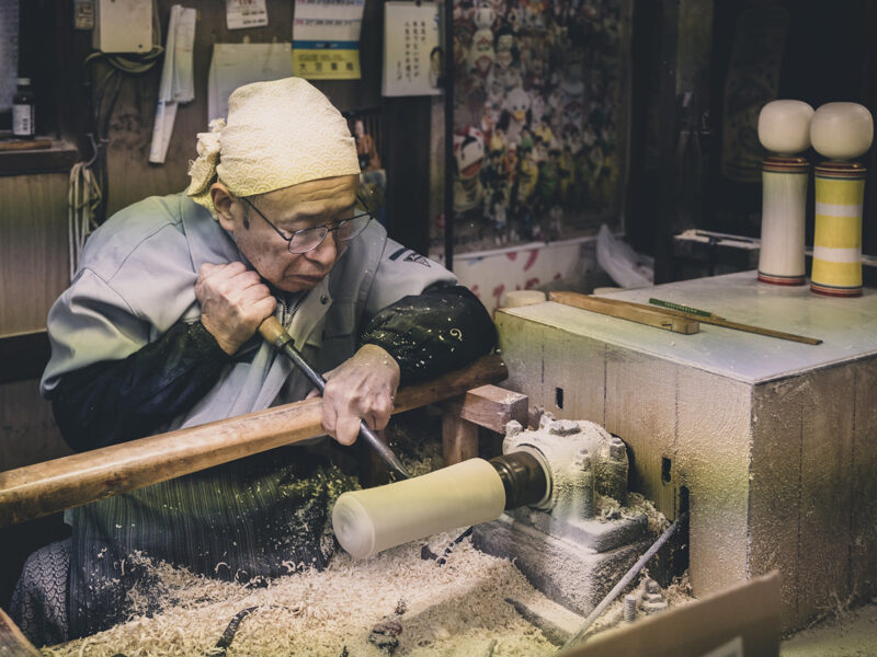 An artisan making a kokeshi doll