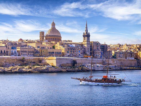 Boat in the Marsamxett Harbour of Valletta, Malta, with a view of the Cathedral of Saint Paul. On of the stops in Viking Cruises