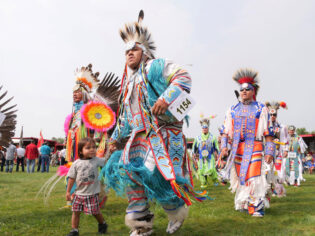 tribal dancers in colourful costumes at United Tribes Technical College (UTTC) International Powwow