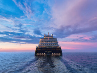 Explora Journey's Explora II cruising under a purple blue sky.