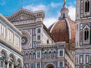 The Duomo peeking through beautiful buildings in Florence.