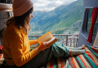 woman reading in van on top of the swiss alps