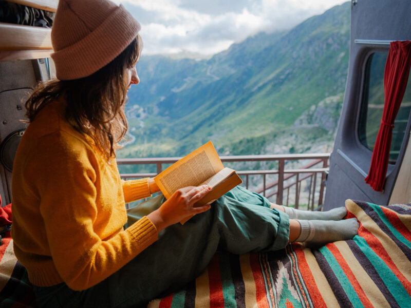 woman reading in van on top of the swiss alps