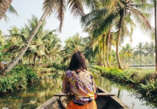 A young woman kayaks through the backwaters of Monroe Island in Kollam District, Kerala, South India.