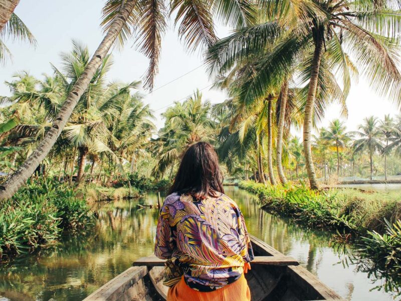 A young woman kayaks through the backwaters of Monroe Island in Kollam District, Kerala, South India.