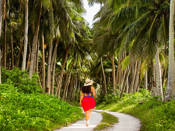 woman walking through Falealupo in samoa