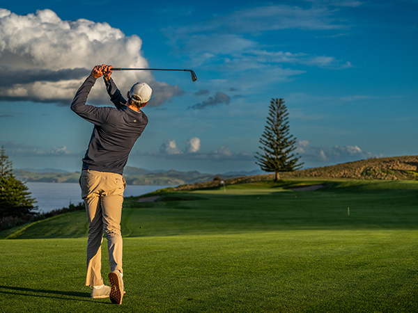 a golfer ont he course at Kauri Cliffs Golf Course new zealand