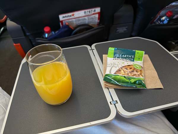 a snack and drink onboard Jetstar’s Boeing 787 Dreamliner Business Class