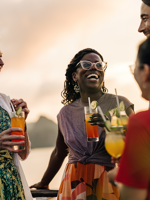 A group of people from Intrepid Travel sharing a drink during sunset in Halong Bay.