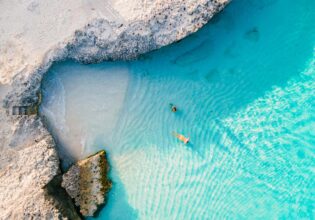 a couple of men and women on the beach of Tres Trap Aruba Caribbean Island. Tres Trapi Bay is popular with locals for snorkeling and diving in the turqouse colored ocean