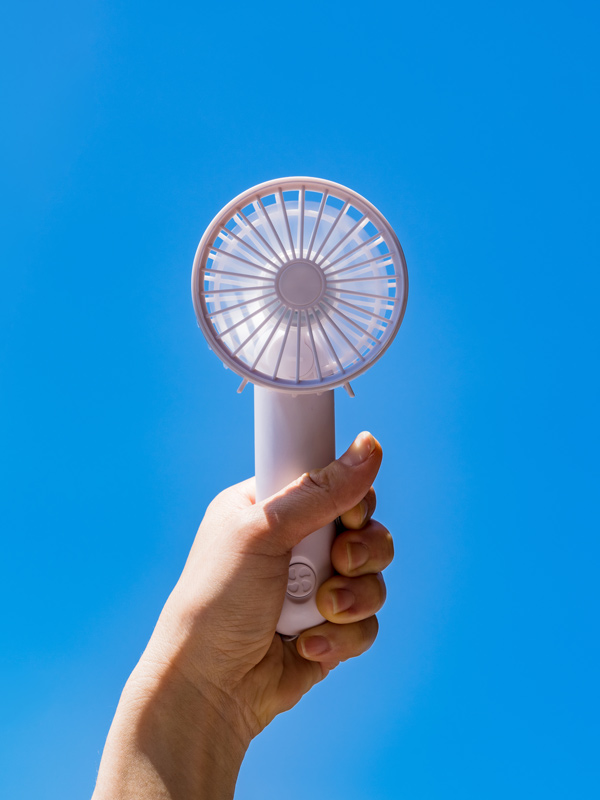 Portable handy fan in summer blue sky