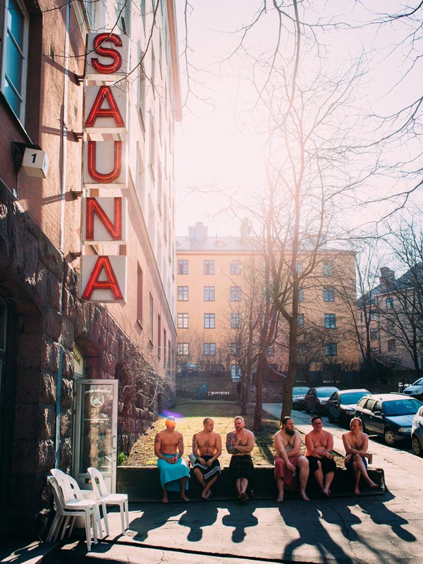 Men gather outside Kotiharju sauna to cool off in Helinski